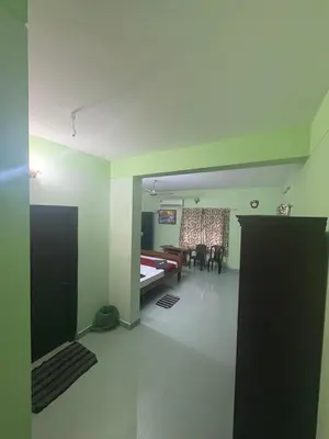 a living room with a bed and a dining room at GK residency in Kozhikode