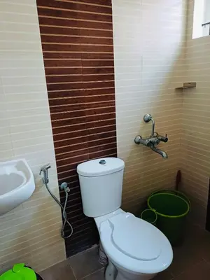 a bathroom with a toilet and a sink at very spacious furnished apartment in Guruvāyūr