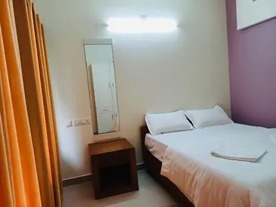a small room with a bed and a mirror at very spacious furnished apartment in Guruvāyūr