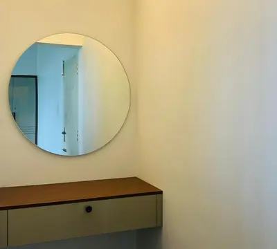 a circular mirror on the wall of a bathroom at Bison Trails Valley View Kothagiri Ooty Tamilnadu in Kotagiri