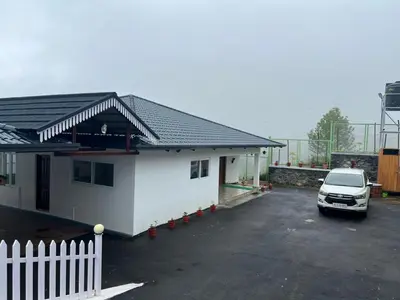 a car parked in a parking lot next to a house at Bison Trails Valley View Kothagiri Ooty Tamilnadu in Kotagiri