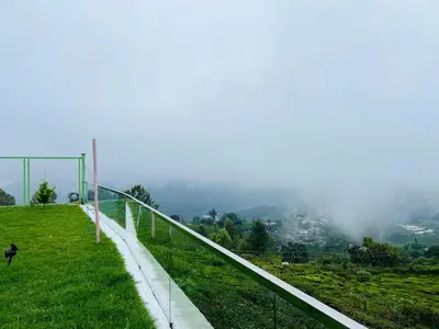 a fence on a hill with a view of a city at Bison Trails Valley View Kothagiri Ooty Tamilnadu in Kotagiri