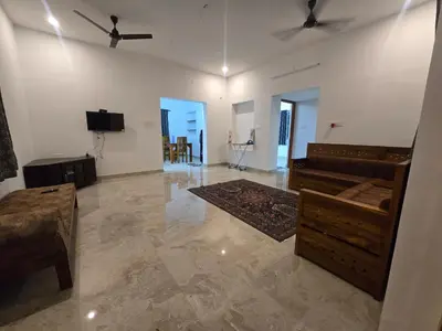 a living room with a couch and a tv at Eachanari Karpaga Rathinam Residency By Shivalaya Stays in Coimbatore