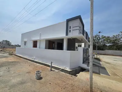 a white house in the middle of a lot at Eachanari Karpaga Rathinam Residency By Shivalaya Stays in Coimbatore