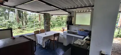 a kitchen and dining room with a table and a kitchen and a window at Echupary Estate cottage in Gonikoppal