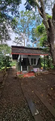 a small house with a bench in front of it at Echupary Estate cottage in Gonikoppal