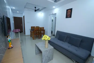 a living room with a blue couch and a table at Janaki Heavens, 1 BHK Apartment in Guruvāyūr