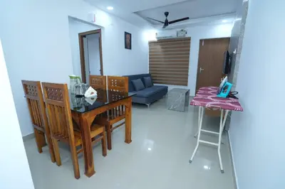 a living room with a table and a couch at Janaki Heavens, 1 BHK Apartment in Guruvāyūr