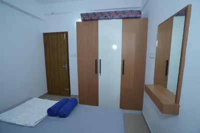 a bathroom with a mirror and blue towels on the floor at Janaki Heavens, 1 BHK Apartment in Guruvāyūr