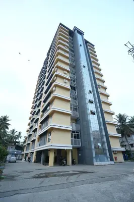 a large apartment building with a lot of windows at Janaki Heavens, 1 BHK Apartment in Guruvāyūr