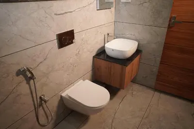a bathroom with a toilet and a sink at Kashmeeram Resort in Vayittiri