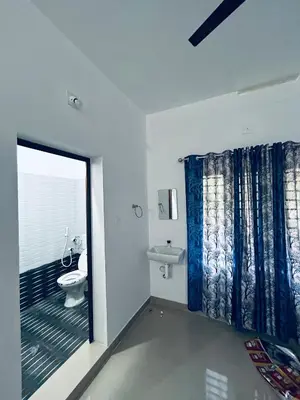 a bathroom with a toilet and a sink and a window at Vyshnavi 2 BHK AC Apartment in Thanniyam