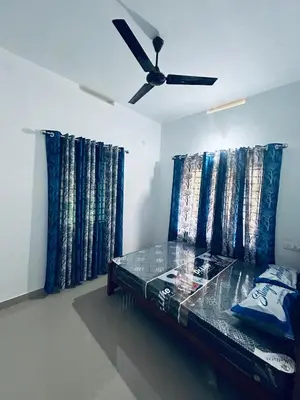 a bedroom with a bed with a ceiling fan at Vyshnavi 2 BHK AC Apartment in Thanniyam