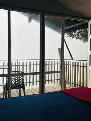 a bedroom with a view of the ocean through glass at Hill wood nature touch resort in Pinangode