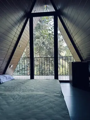 a large bed in a room with a large window at Hill wood nature touch resort in Pinangode