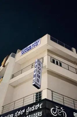 a white building with a sign on top of it at Forum Stay in Mysore