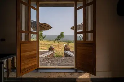 an open door with a view of a field at Safari Farms Resorts and Leisure in Kandivalli