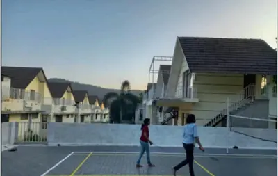 two women are walking on a tennis court at The NEST VILLAS in Athirappilly