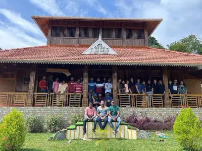 a group of people sitting on the porch of a building at JackRoot Athirappilly in Kallana
