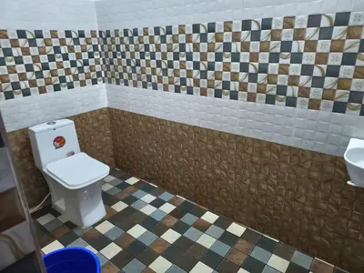 a bathroom with a toilet and a sink at Flavoury Restaurant & Rooms in Paithalmala