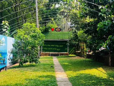 a garden with a walkway in a greenhouse at Flavoury Restaurant & Rooms in Paithalmala
