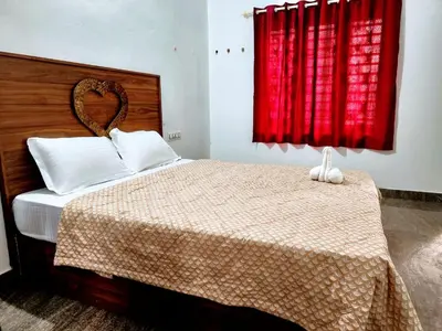 a bedroom with a bed with a red curtain at Flavoury Restaurant & Rooms in Paithalmala