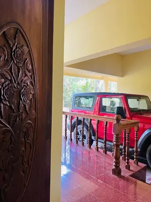 a red jeep parked in a room with a railing at Chirakkal Heritage Luxury Homestay in Manjeri