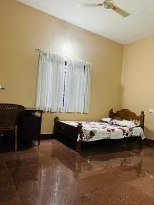 a bedroom with a bed and a window at Chirakkal Heritage Luxury Homestay in Manjeri