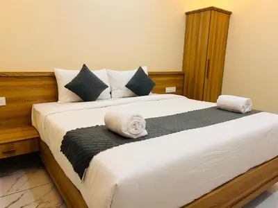 a bedroom with a large bed with towels on it at FORTUNE BANASURA Resort in Kalpetta