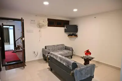 a living room with a couch and a tv at Radisson in Madikeri