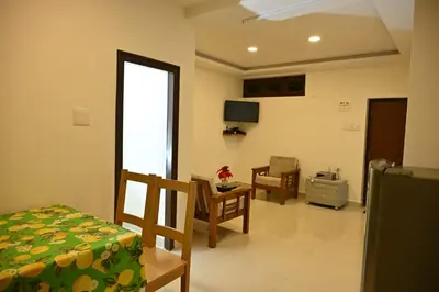 a room with a bed and a table and a tv at Radisson in Madikeri