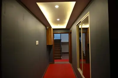 a hallway with a red carpet and a ceiling at Radisson in Madikeri