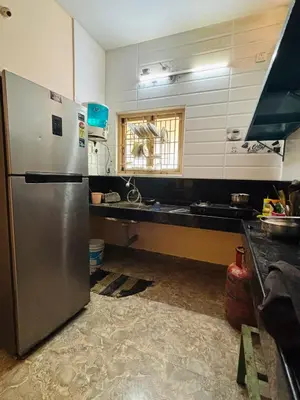 a kitchen with a stainless steel refrigerator and a counter at RoBen Villa in Pollāchi