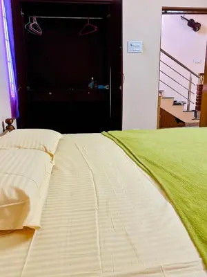 a bed in a room with a large door at RoBen Villa in Pollāchi