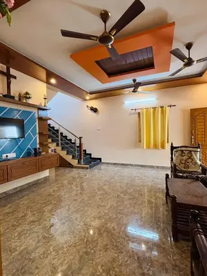 a living room with a ceiling fan and a couch at RoBen Villa in Pollāchi