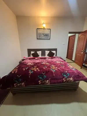 a bedroom with a bed with a red comforter at Blessing holidays ooty in Ooty