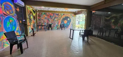 a room with a table and chairs and a colorful wall at Brighton Hostel Stays in Sultan Bathery
