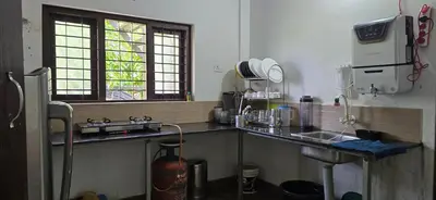 a kitchen with a counter and a sink andwindows at Brighton Hostel Stays in Sultan Bathery