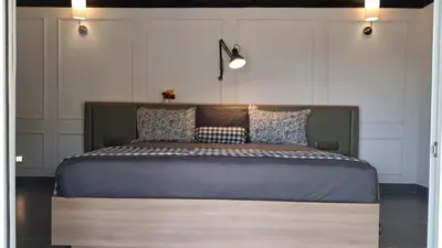 a bedroom with a large bed with a wooden headboard at Vidman Homey Huts in Tindummal