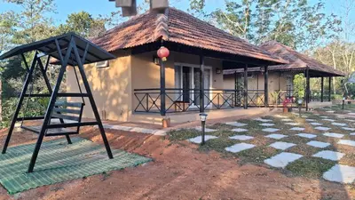 a house with a basketball hoop in front of it at Vidman Homey Huts in Tindummal