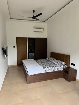 a bedroom with a bed and a ceiling fan at Bhoomi in Mysore