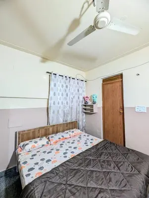 a bedroom with a bed and a ceiling fan at Hazel's ELiTE Homestay 3BHK in Mysore