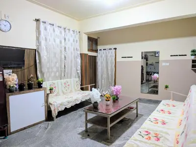 a living room with two chairs and a table at Hazel's ELiTE Homestay 3BHK in Mysore