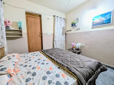 a small bedroom with a bed and a door at Hazel's ELiTE Homestay 3BHK in Mysore