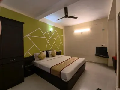a bedroom with a bed with a green wall at Hill View Residency in Kalpetta