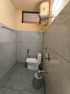 a small bathroom with a toilet and a window at Hill View Residency in Kalpetta
