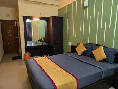 a bedroom with a bed and a desk in it at Hill View Residency in Kalpetta