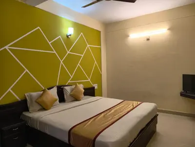 a bedroom with a bed with a yellow and white wall at Hill View Residency in Kalpetta