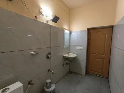 a bathroom with a shower with a sink and a sink at Hill View Residency in Kalpetta