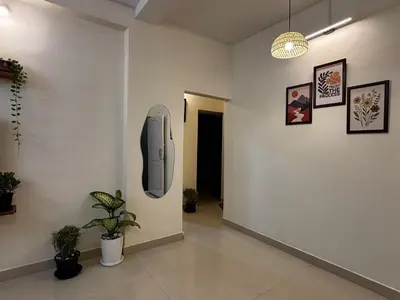 a hallway with a tv on a wall with plants at Hazel's ELiTE Homestay 2bhk in Mysore